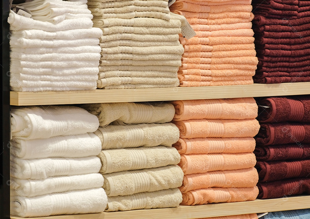 Toalhas coloridas são colocadas em prateleiras em lojas de departamento, coágulo