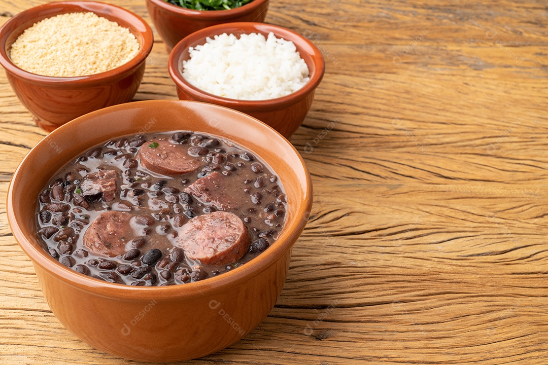 Feijoada típica brasileira com farofa, arroz, couve e espaço para copiar.