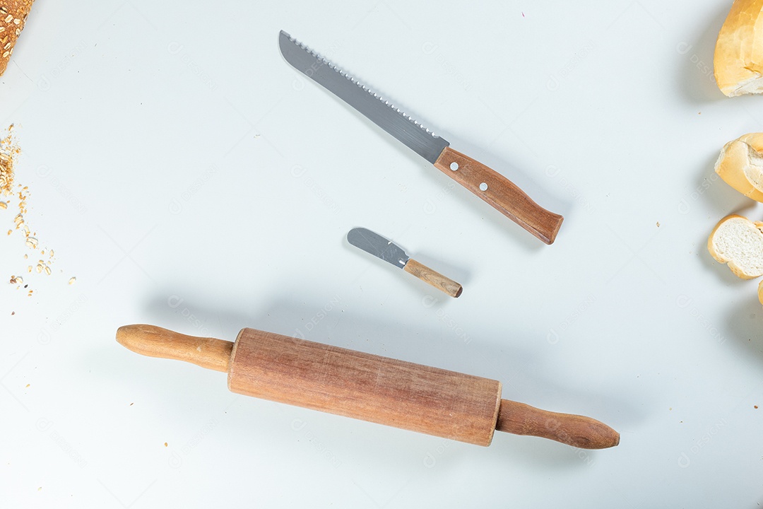 rolo e facas, utensílios para fazer pão na mesa branca.