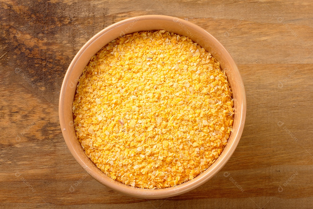 Farinha de fubá crua usada na polenta, em tigela de madeira sobre rústico