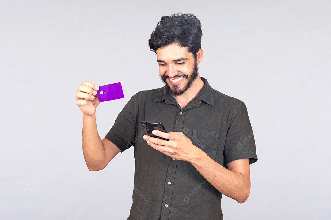 Homem jovem barbudo usando seu celular para fazer compras cartão de crédito sobre fundo isolado branco