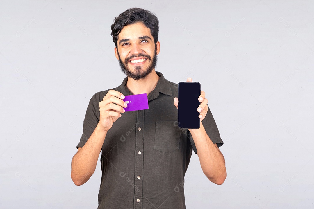 Homem jovem barbudo usando seu celular para fazer compras cartão de crédito sobre fundo isolado branco