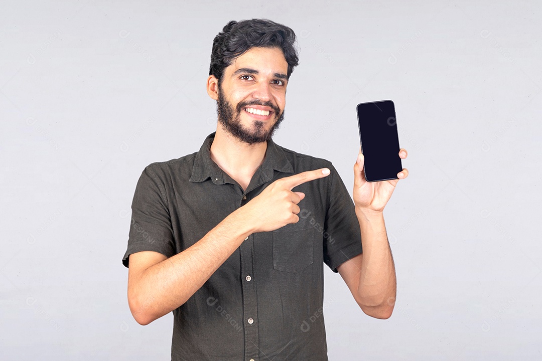 Bearded young man holding cell phone smartphone over white isolated background