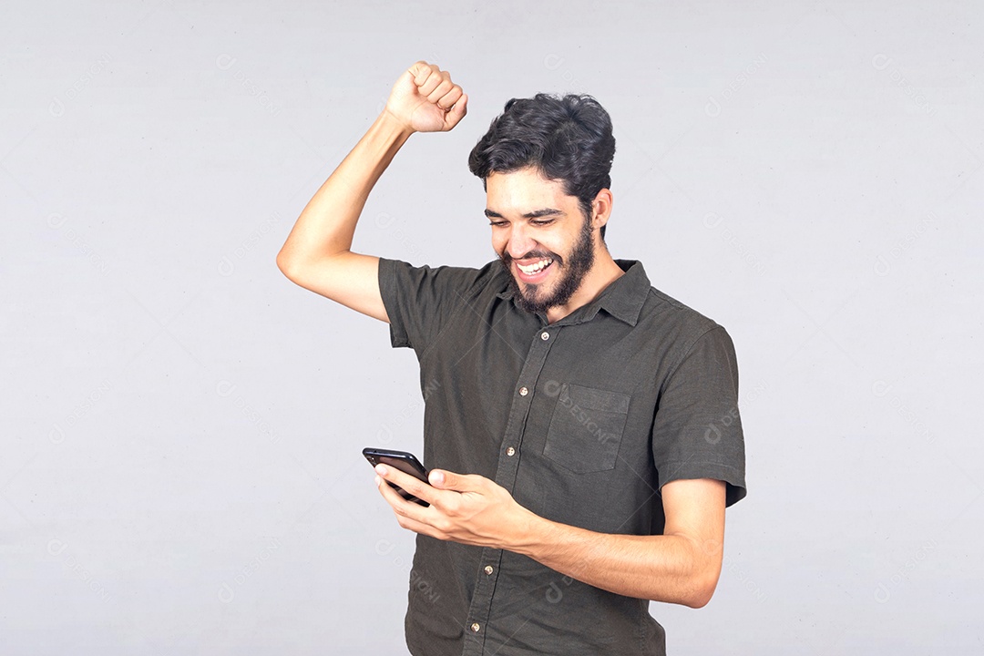 Homem jovem barbudo segurando celular smartphone sobre fundo isolado branco