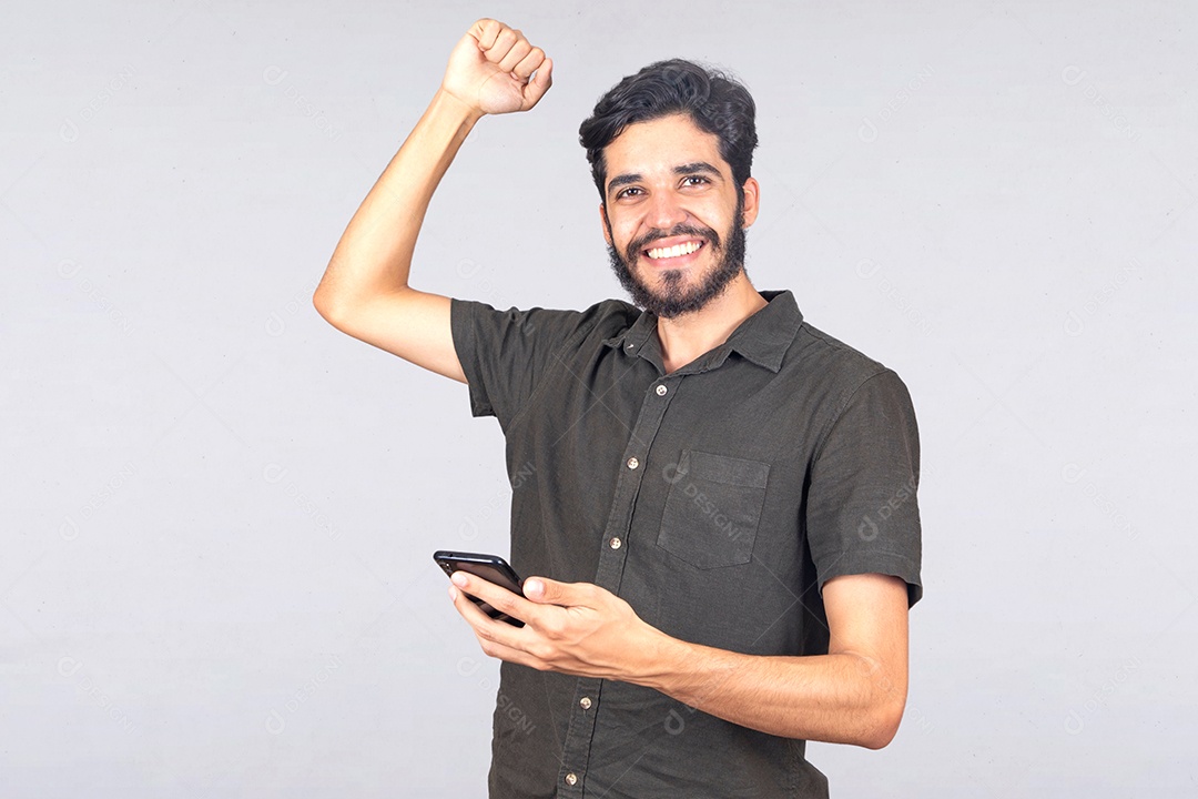 Homem jovem barbudo segurando celular smartphone sobre fundo isolado branco