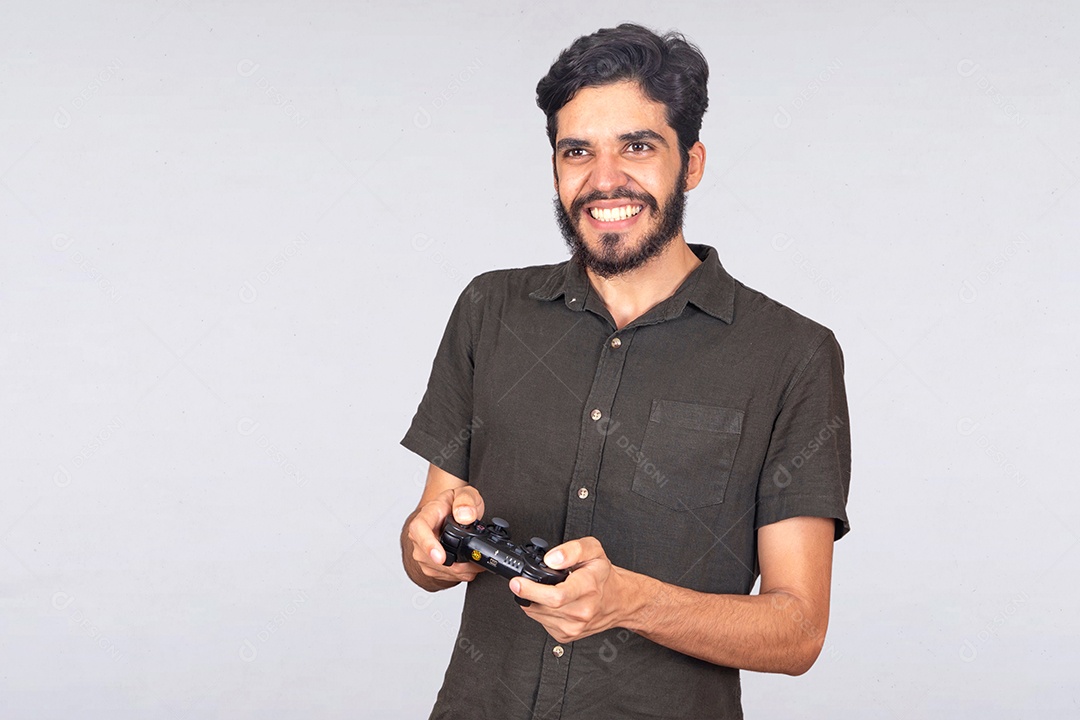 Homem jovem barbudo segurando controle de videogame jogos sobre fundo isolado branco