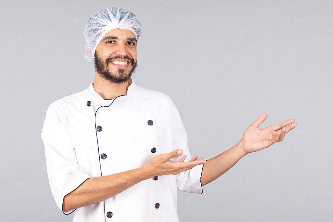 Homem jovem barbudo usando avental branco chefe de cozinha sobre fundo isolado branco