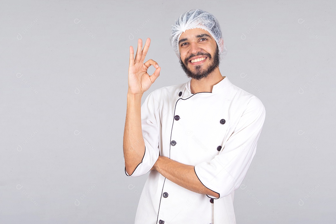 Homem jovem barbudo usando avental branco chefe de cozinha sobre fundo isolado branco