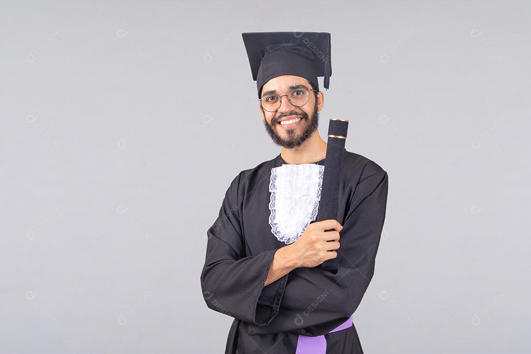 Homem jovem barbudo usando beca de formatura sobre fundo isolado branco