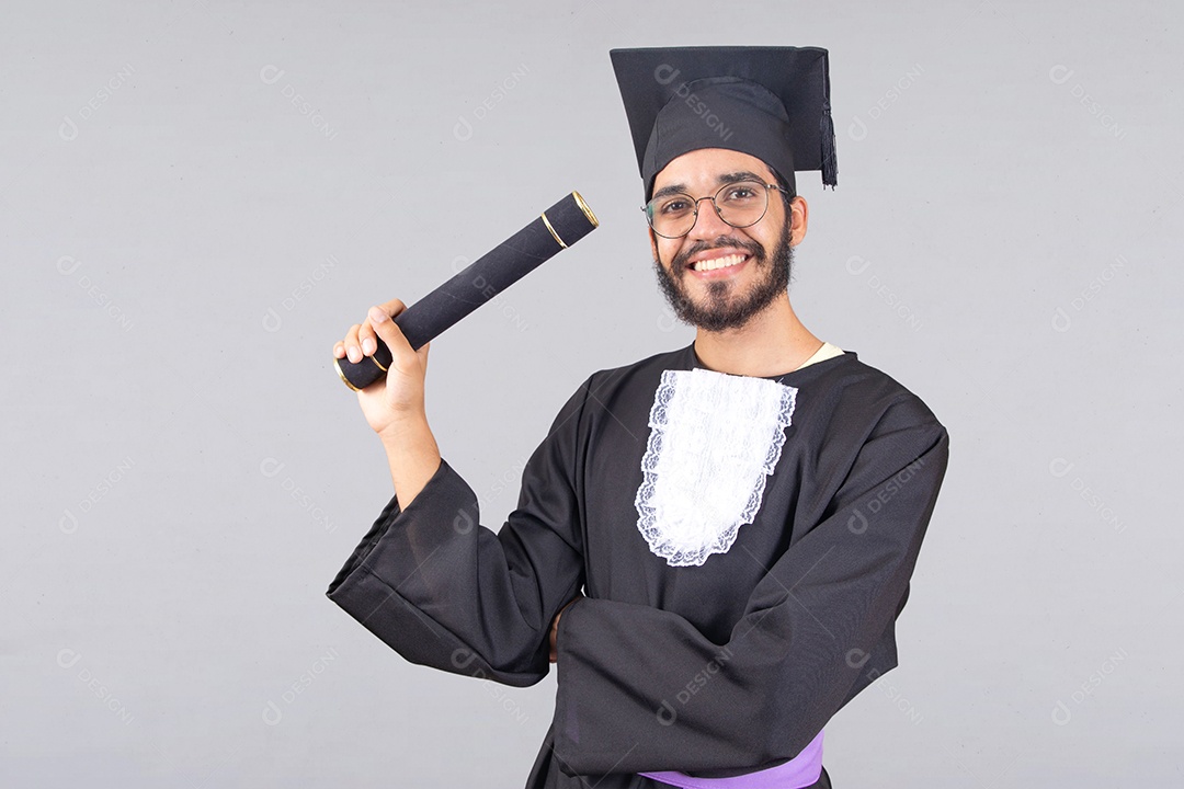 Homem jovem barbudo usando beca de formatura sobre fundo isolado branco