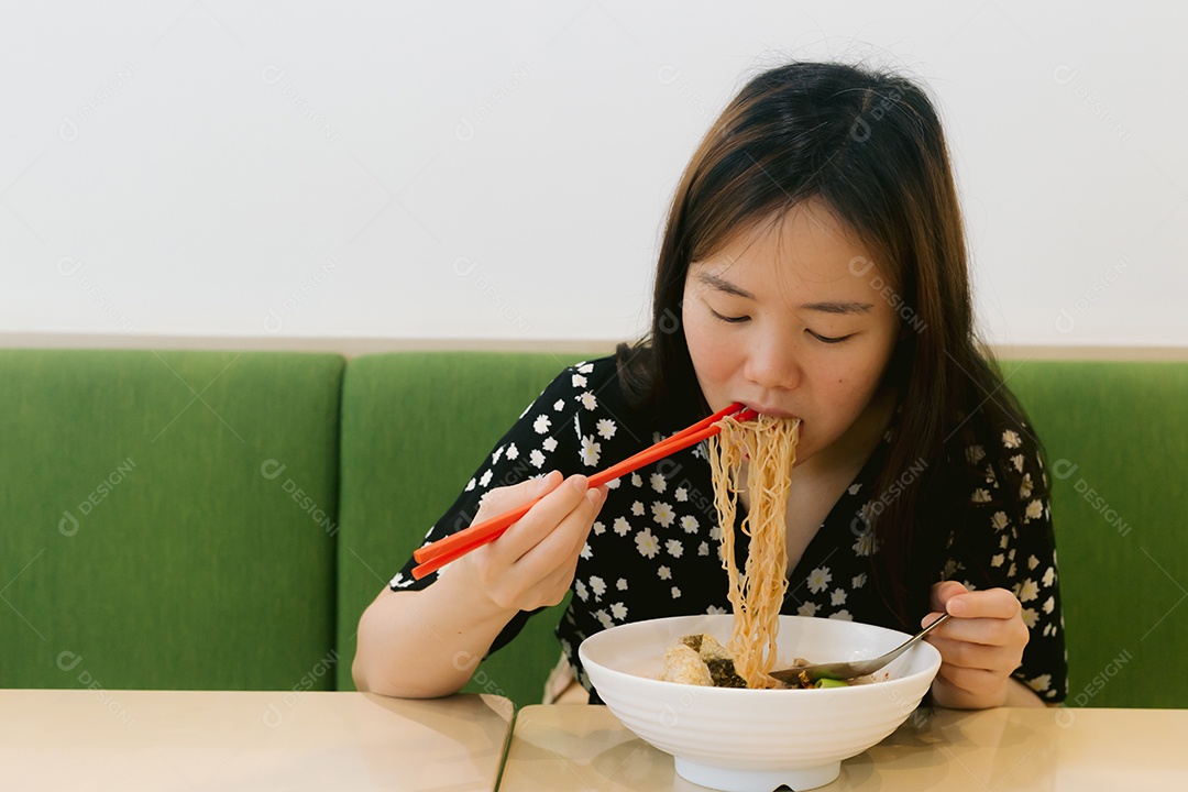 Linda mulher asiática se alimentando sobre fundo desfocado