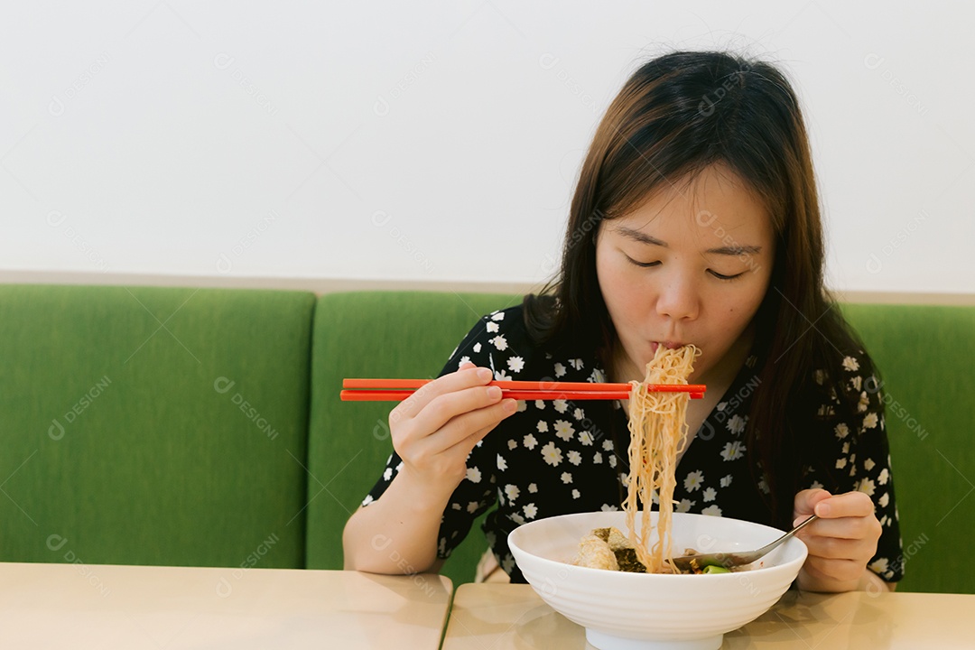 Linda mulher asiática se alimentando sobre fundo desfocado