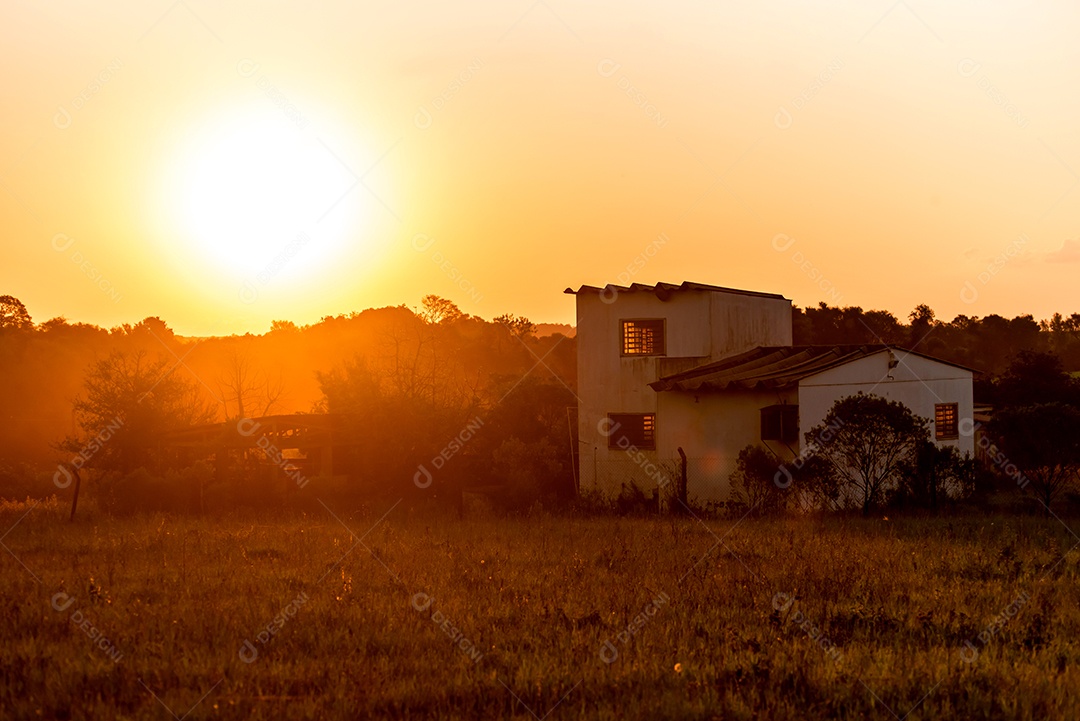 Casa de campo abandonada ao pôr do sol amarelo