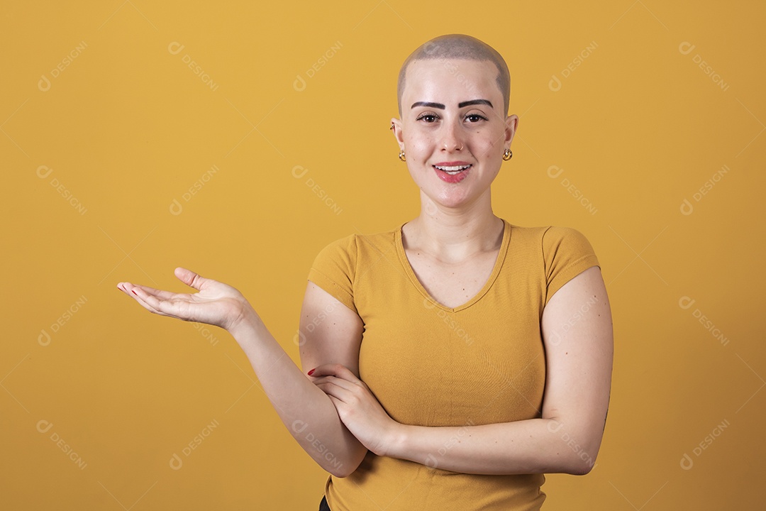 Linda mulher jovem careca apontando para o lado,  em conceito outubro rosa