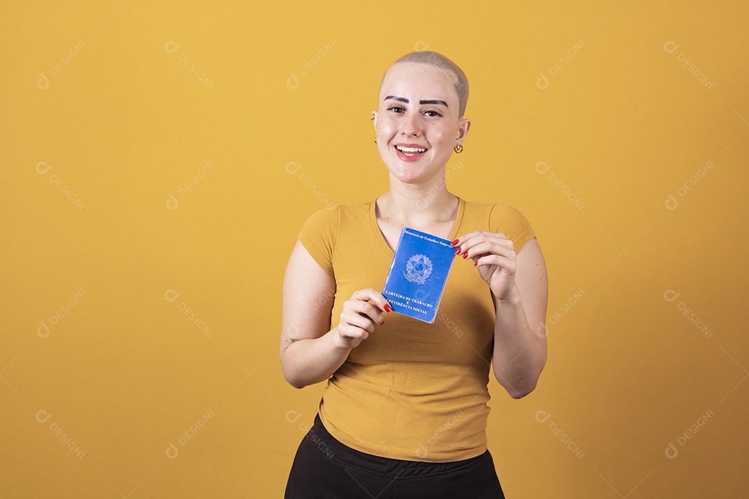 Linda mulher jovem careca segurando uma carteira de trabalho da previdência social,  em conceito outubro rosa