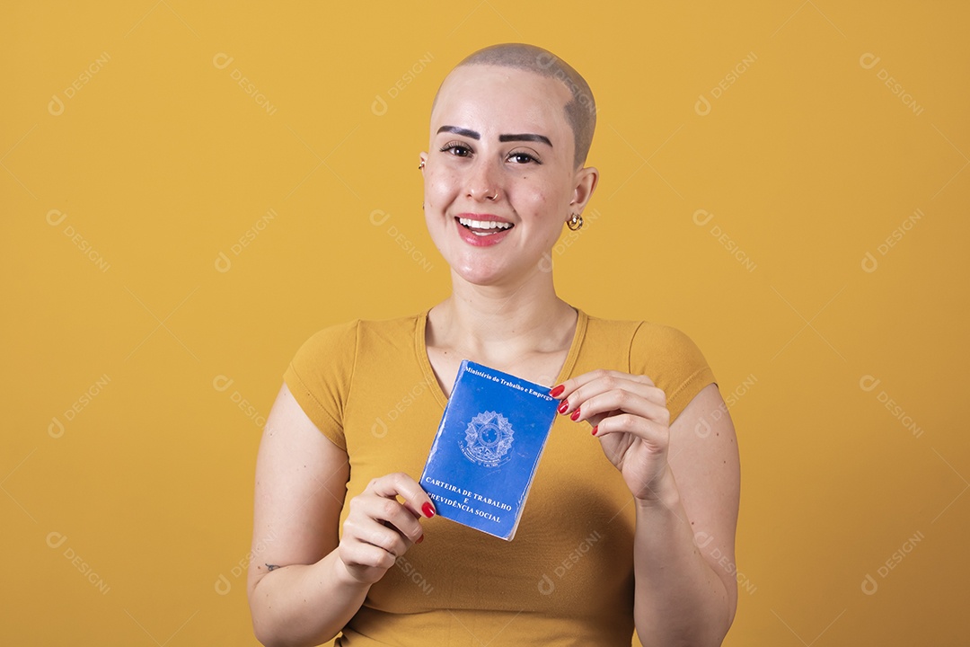 Linda mulher jovem careca segurando uma carteira de trabalho da previdência social,  em conceito outubro rosa