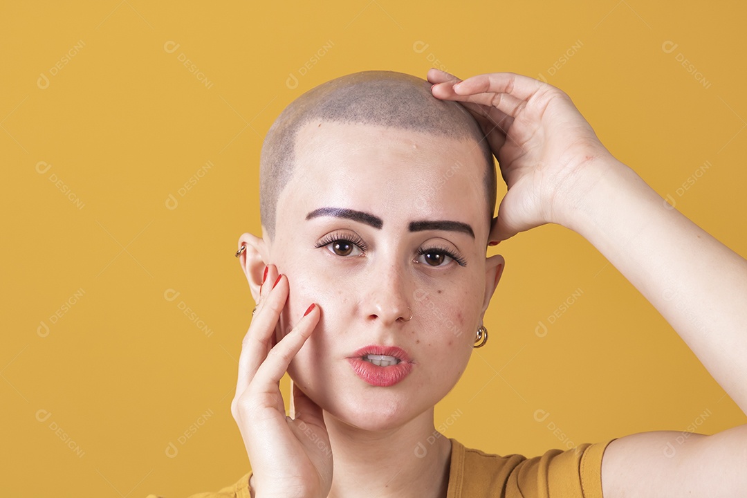 Mulher jovem careca usando blusa bege em conceito de câncer, outubro rosa