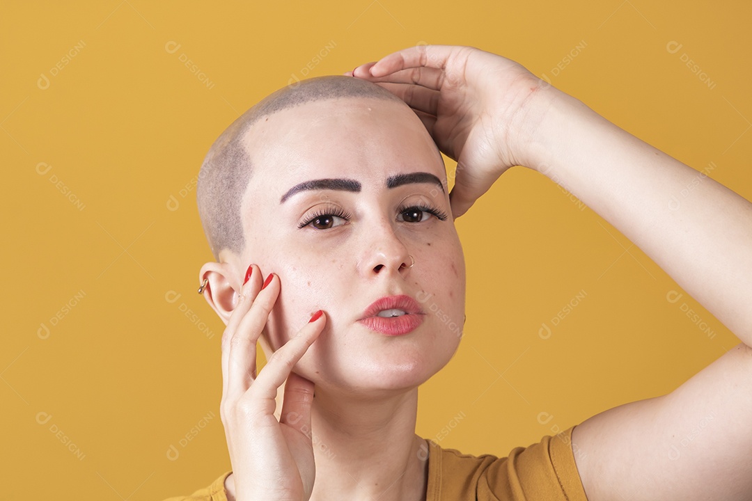 Mulher jovem careca usando blusa bege em conceito de câncer, outubro rosa