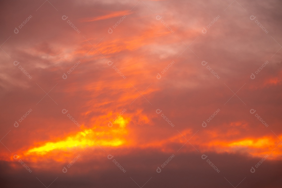 Lindas nuvens alaranjadas gradientes e luz solar no céu azul