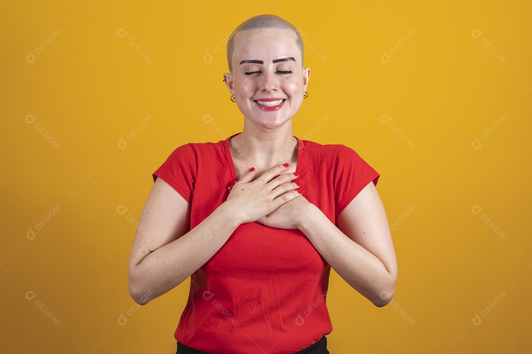 Mulher jovem careca usando blusa vermelha em conceito de câncer, outubro rosa