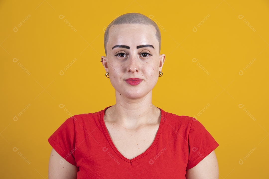 Mulher jovem careca usando blusa vermelha em conceito de câncer, outubro rosa