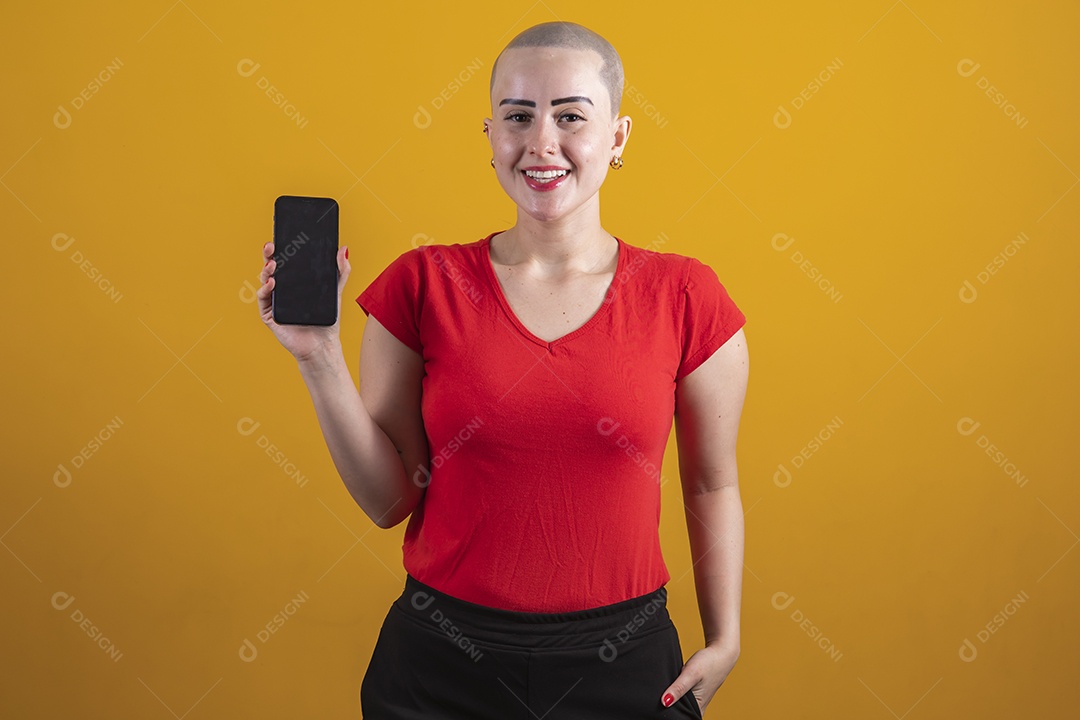 Mulher jovem careca usando blusa vermelha segurando um celular