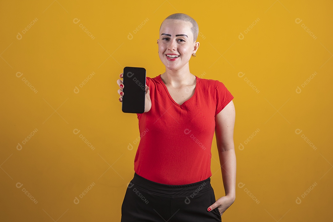 Bald young woman wearing a red shirt holding a cellphone