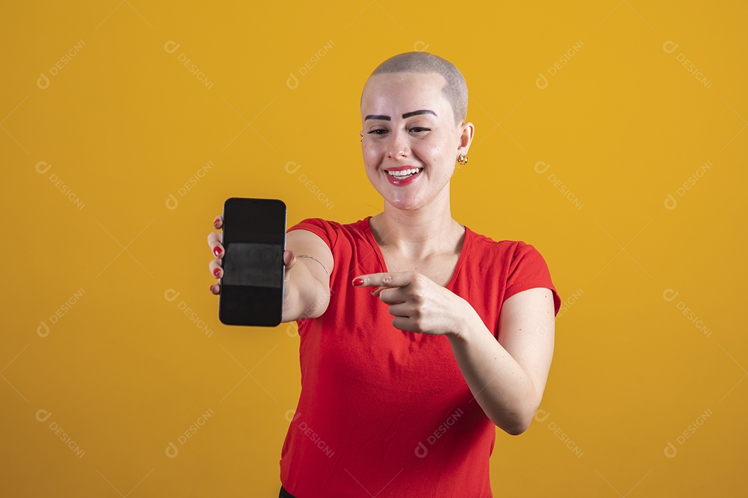 Mulher jovem careca usando blusa vermelha segurando um celular