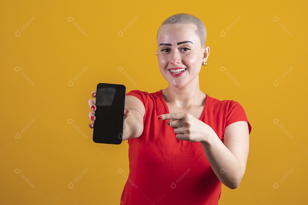 Mulher jovem careca usando blusa vermelha segurando um celular