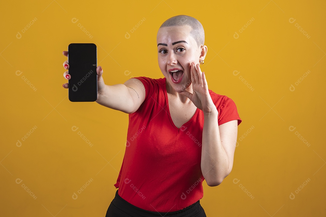 Mulher jovem careca usando blusa vermelha segurando um celular