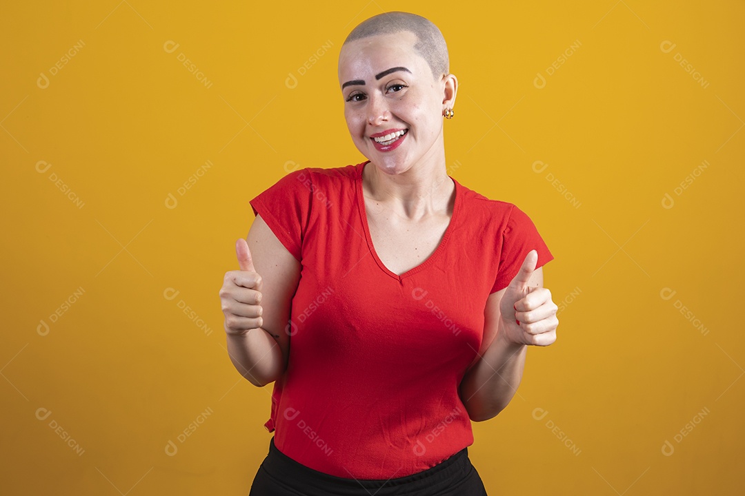 Mulher jovem careca usando blusa vermelha em conceito de câncer, outubro rosa