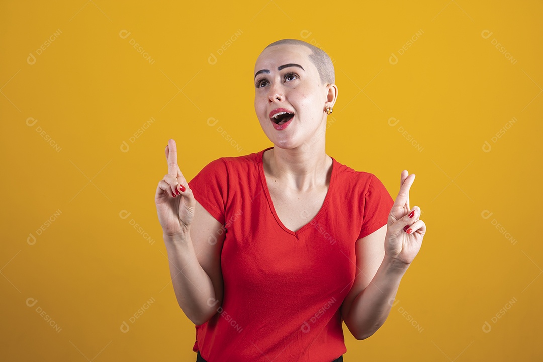 Mulher jovem careca usando blusa vermelha em conceito de câncer, outubro rosa