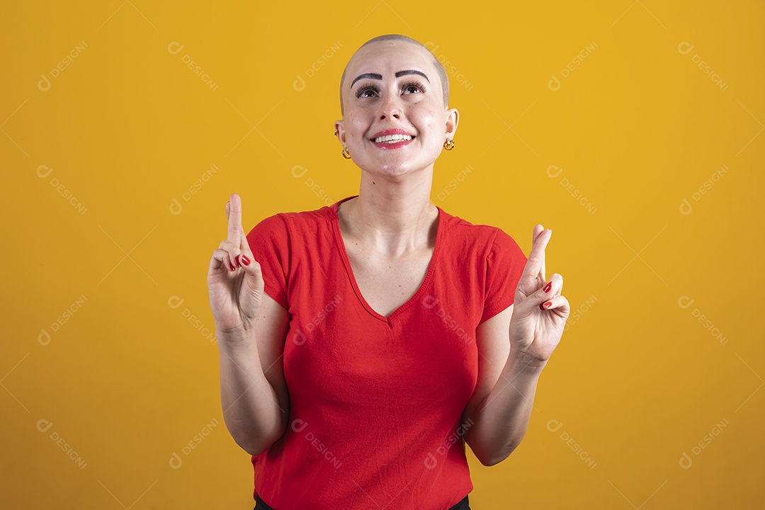 Mulher jovem careca usando blusa vermelha em conceito de câncer, outubro rosa