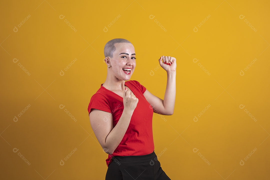 Mulher jovem careca usando blusa vermelha em conceito de câncer, outubro rosa