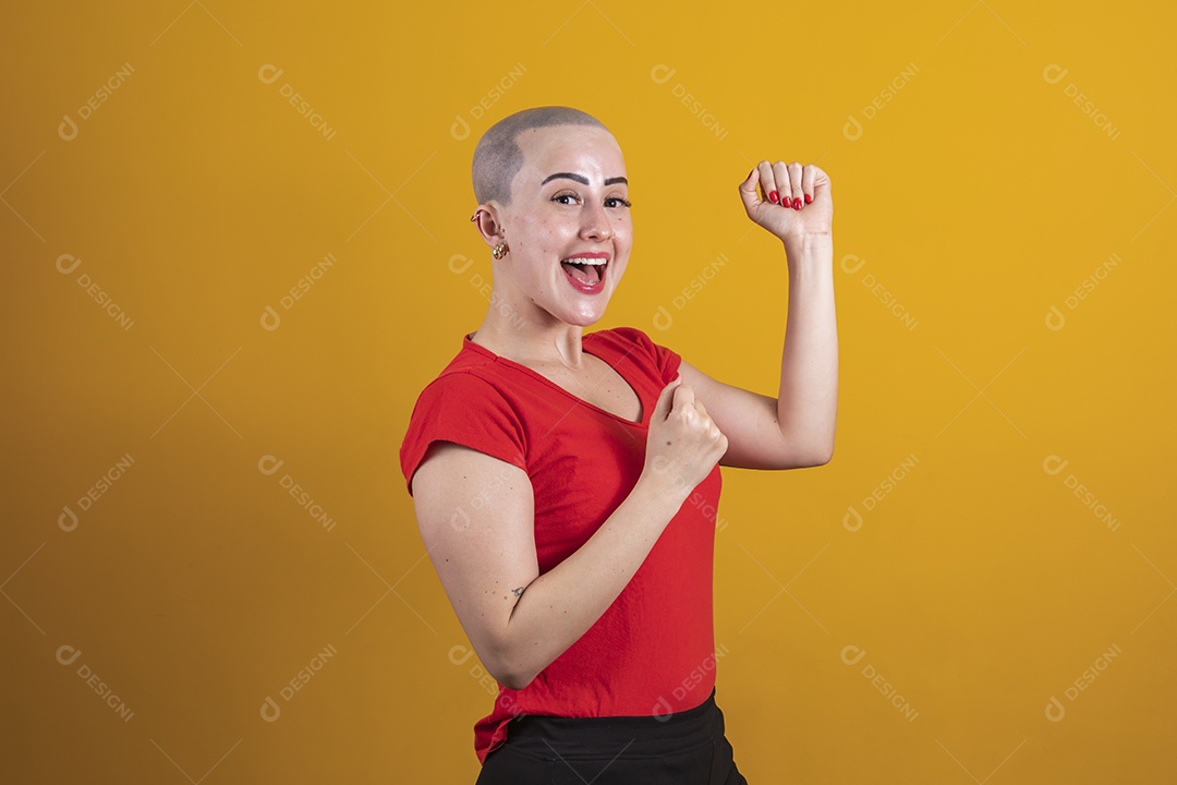 Mulher jovem careca usando blusa vermelha em conceito de câncer, outubro rosa