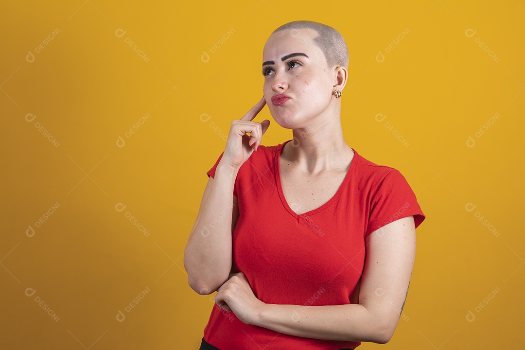 Mulher jovem careca usando blusa vermelha em conceito de câncer, outubro rosa