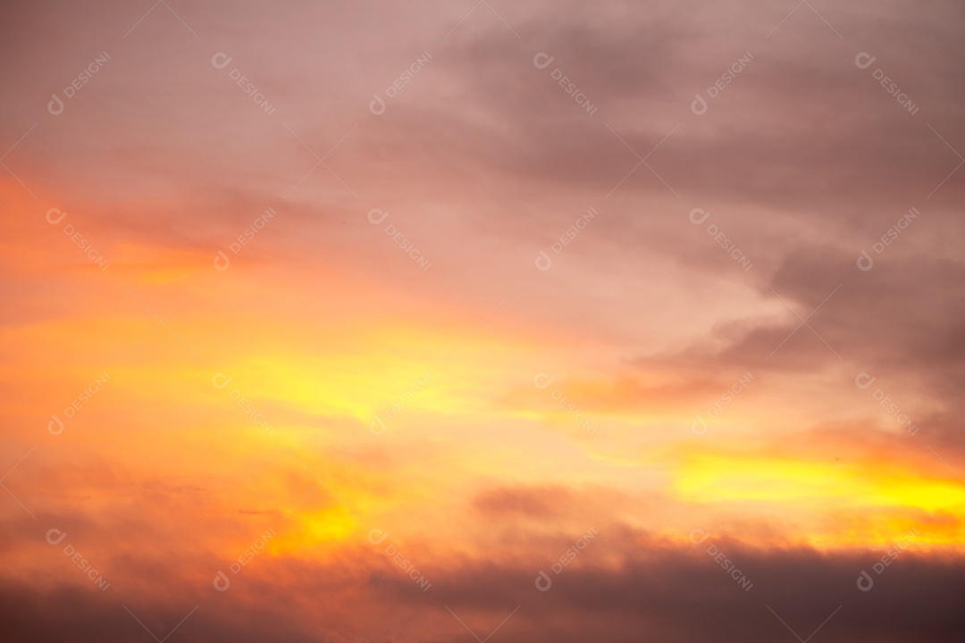 Lindas nuvens alaranjadas gradientes e luz solar no céu azul