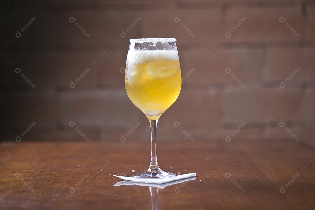 Taça com cerveja sobre a mesa de madeira