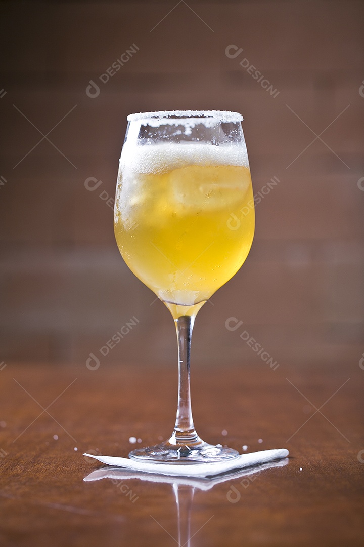 Taça com cerveja sobre a mesa de madeira