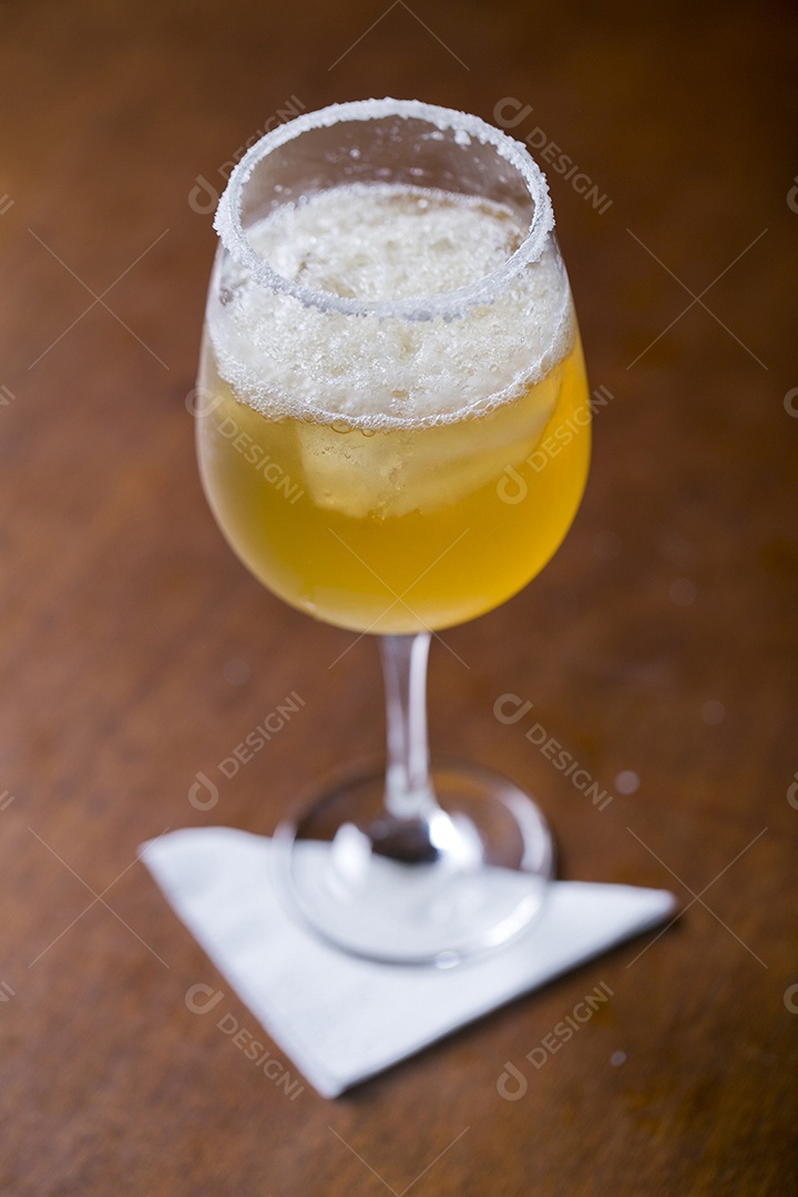 Taça com cerveja sobre a mesa de madeira