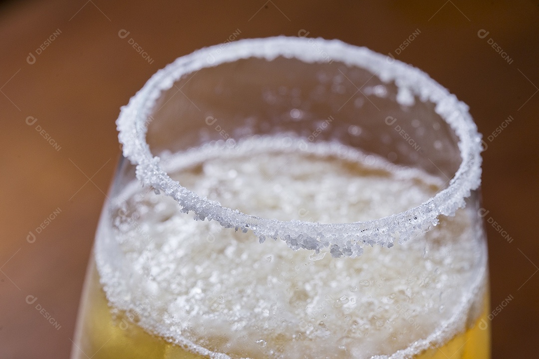 Taça com cerveja sobre a mesa de madeira