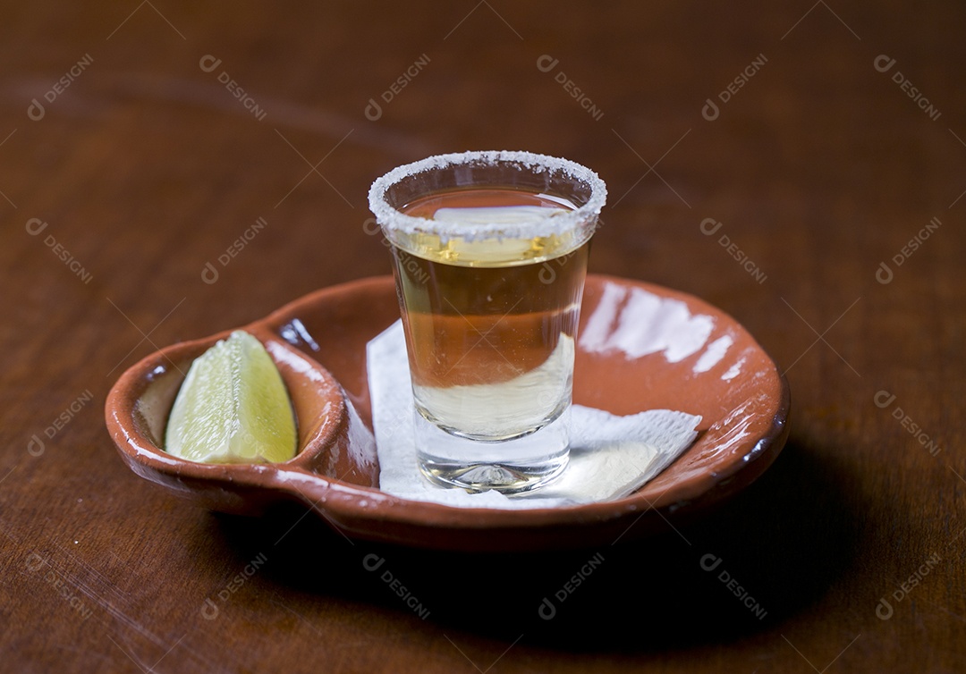 Copo de shot com dose de bebida e fatia de limão