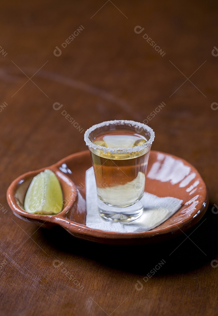 Copo de shot com dose de bebida e fatia de limão