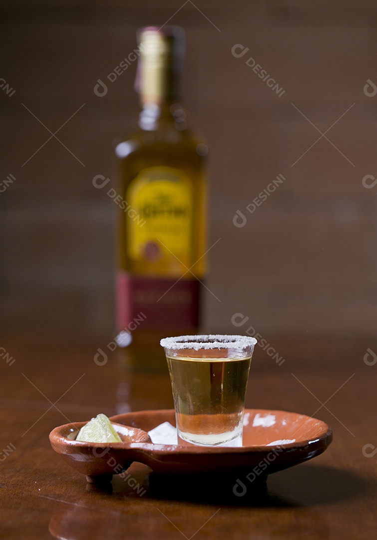 Copo de shot com dose de bebida e fatia de limão