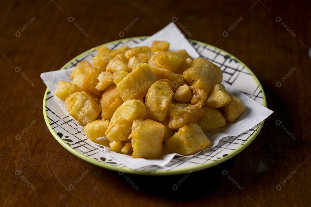Porção de mandioca frita sobre a mesa