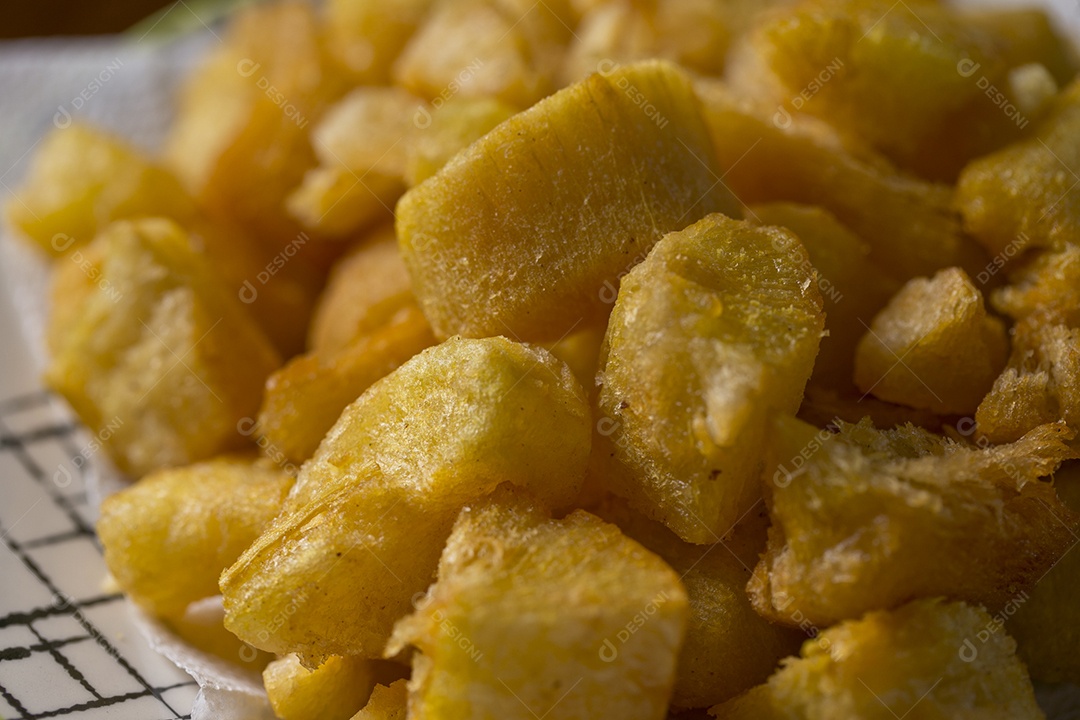 Porção de mandioca frita sobre a mesa