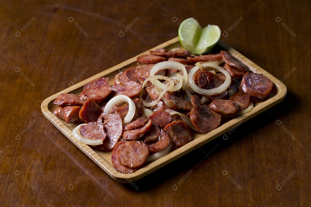 Porção de calabresa acebolada sobre a mesa