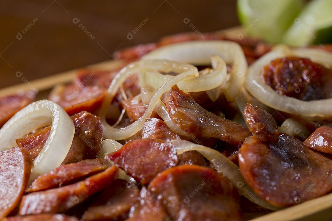 Porção de calabresa acebolada sobre a mesa