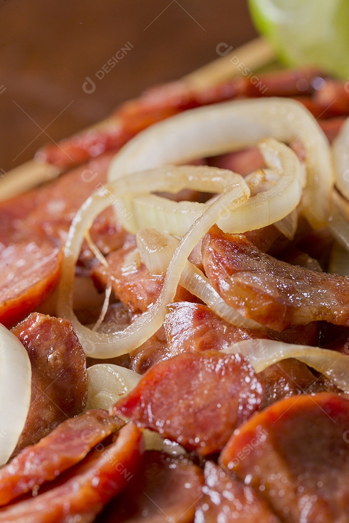 Porção de calabresa acebolada sobre a mesa