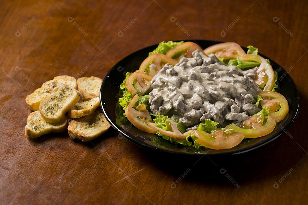 Porção de fígado acebolado sobre a mesa